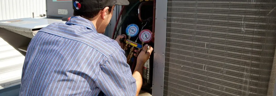 HVAC technician servicing a condenser unit in Skippack