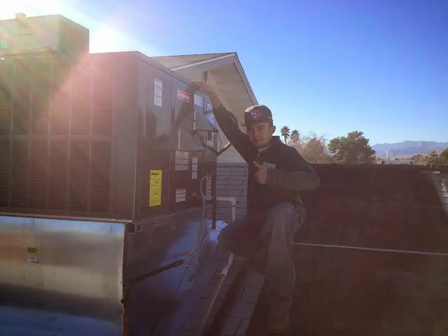 HVAC technician performing Air Duct Repair on a rooftop unit in Skippack